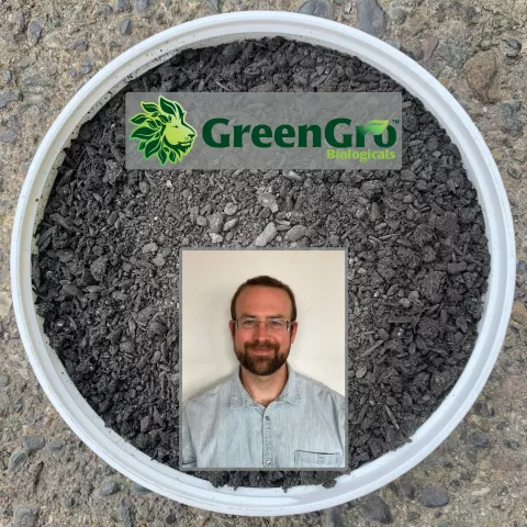 Background: a bucket of charged biochar. In the foreground at the top quarter of the image is the logo for GreenGro Biologicals, beneath this, starting at the middle of the image, is a headshot of podcast guest Mark Ervin